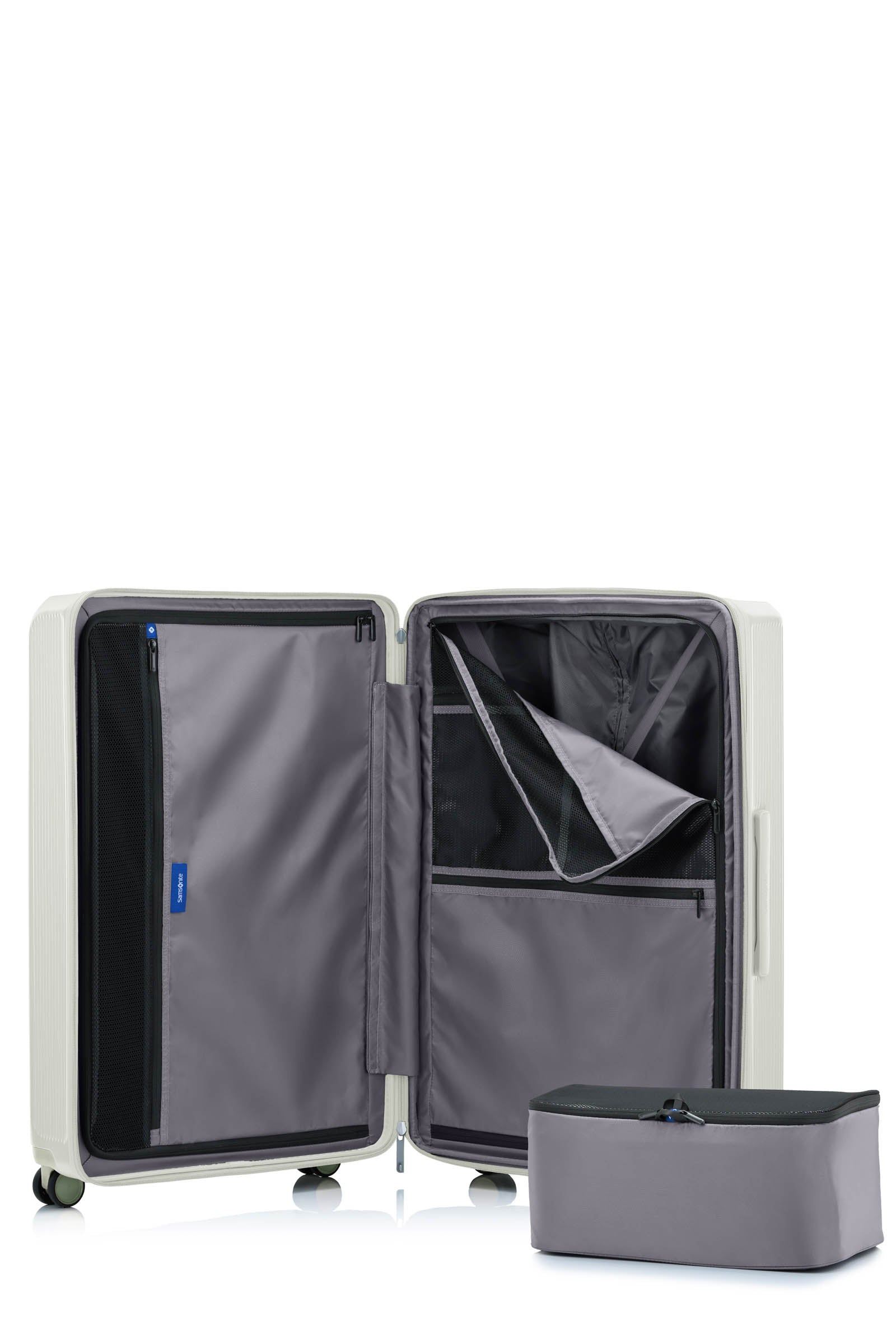 Interior view of the Samsonite Voypod Spinner large in Ivory, showing the grey Recyclex™ lining, compression straps, and zippered organization pockets. Shop Now Online